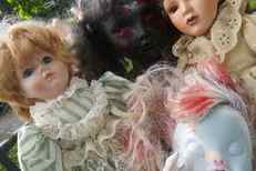 A close-up of four doll heads together.