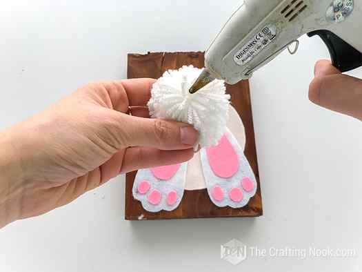 Gluing the pom pom bunny butt on the top edge of the white circle