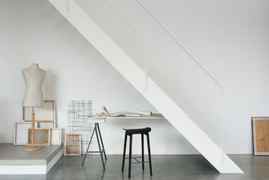 Dulux White Coloured Workspace With Neutral Coloured Mannequin Torso And Table Under A White Staircase
