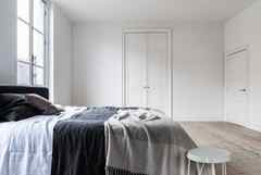 Dulux White Coloured Bedroom With Light Wooden Flooring And Dark Contrasting Bedding