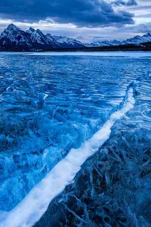 A winter scene of a snow-filled crack in the ice at Abraham Lake, Canada