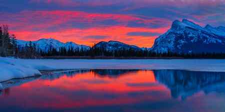 Red sunrise colors over a snow-covered lake at Vermillion Lake, Canada