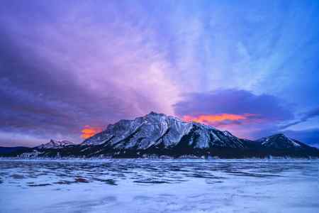 A brilliant sunrise sky over the mountain at Abraham Lake, Canada