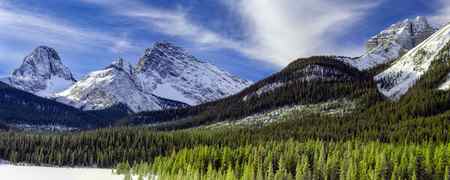 A panoramic view of snow covered mountains in the winter in the Canadian rockies