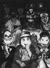 Image detail from a 1962 DC newspaper of several children seated on steps wearing various costumes and masks for Halloween. 