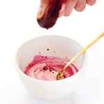 Squeezing beet juice into a bowl to make DIY Natural Food Dye