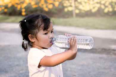 Child drinking from a plastic water bottle.