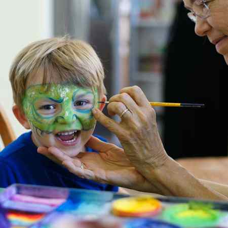 Auntie Stacey face paints a dragon, face and body paint by Auntie Stacey Dennick, San Francisco Bay area face painter