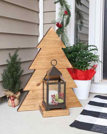DIY wood Christmas tree with glass lantern and Christmas decor on front porch