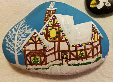 Use this painted rock of a Christmas house as inspiration for your next rock painting