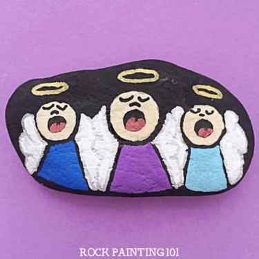 Christmas painted rock with cute little angel carolers