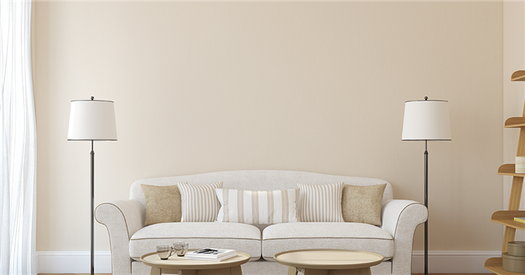 Plain off white sofa in front of warm white wall