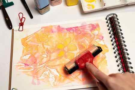 applying acrylic paint with a stencil using a brayer