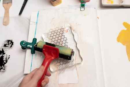 applying acrylic paint on a stamp with a brayer