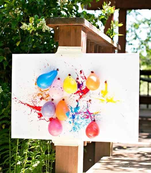 Image shows a canvas with balloons filled with paint stuck to it. Idea from Hello Wonderful