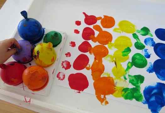 Image shows a set of balloons and paints on top of a piece of paper. Idea from Learning 4 Kids