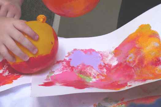 Image shows a kid making balloon painting. Idea from Paper scissor craft