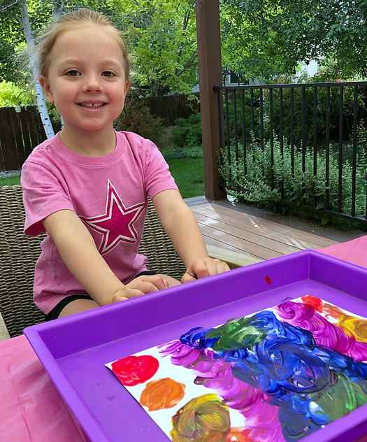 Image shows a little kid excited to create balloon painting art. Idea from Capturing Parenthood