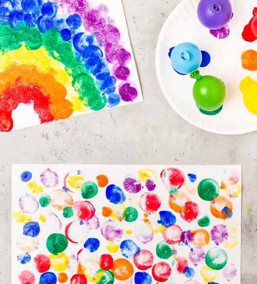 Image shows a rainbow painting made with balloons.