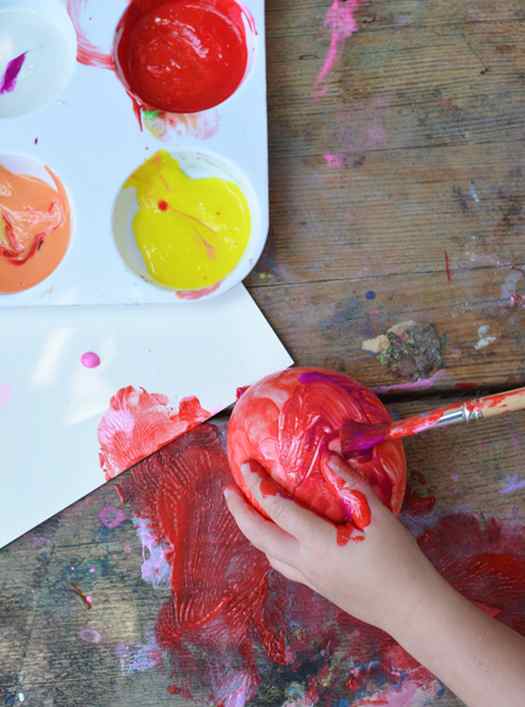 Image shows a kid using a balloon to make a painting. Idea from Meri Cherry