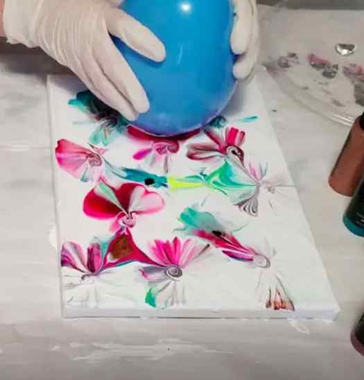 Image shows a kid making a painting using a blue balloon. Idea from Hometalk