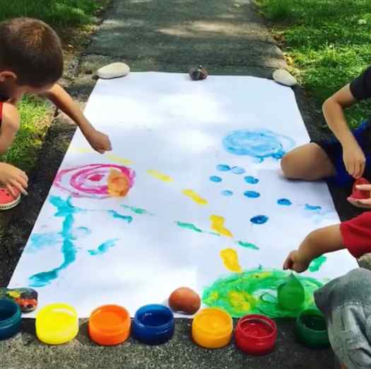 Image shows two kids outside painting with balloons. Idea from Raising Dragons