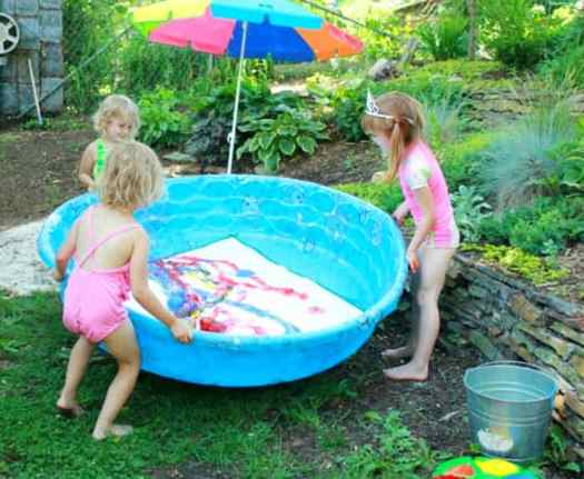 Image shows three kids making balloon art on a pool. Idea from Lets Lasso The moon