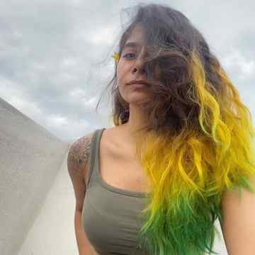 girl-with-curly-hair-falling-on-one-side-of-her-face-with-yellow-and-green-colored-hair-color-tips