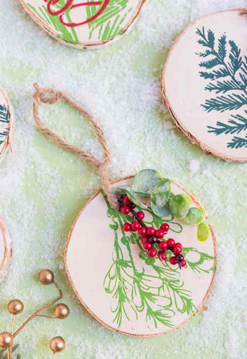 DIY wood slice ornaments with winter greenery