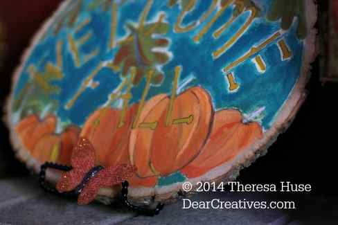 Close up of fall painting on wood round of pumkins with welcome fall stencil lettering_
