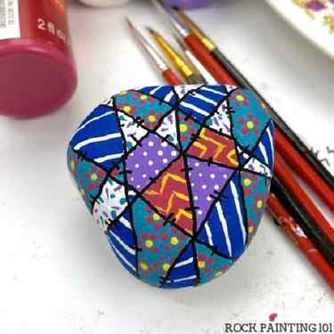 Colorful winter quilt pattern painted on a rock. 