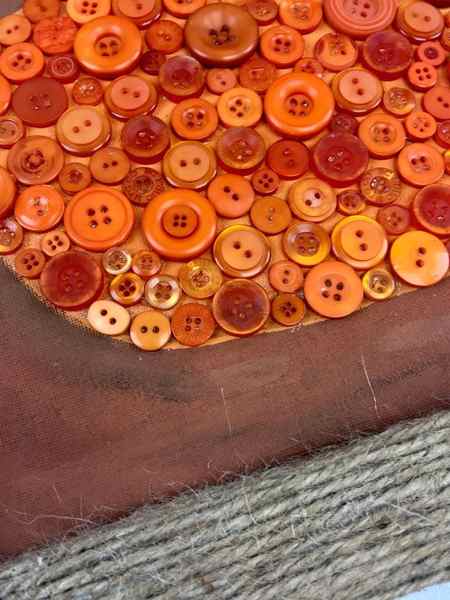 Create whimsical pumpkin button wall art for fall using this easy to follow tutorial. 