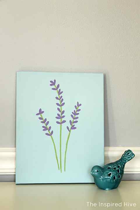 A painting of lavender sprigs next to a small bird sculpture