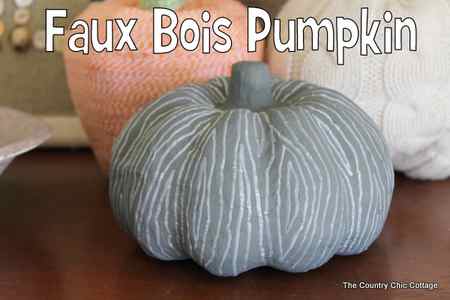 faux bois pumpkin in front of two other decorative craft pumpkins