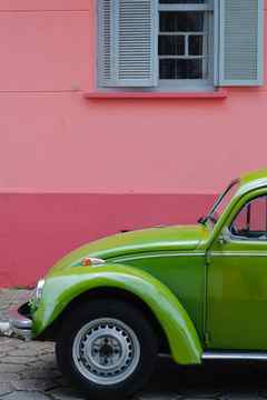 bright green car pops against bright pink wall