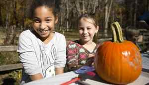 two girls painting a pumpkin