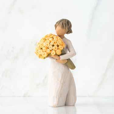 Front/side view of little girl with short brown hair holding a large bouquet of yellow roses
