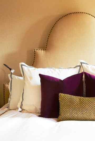 beige bedroom with pink velvet pillows
