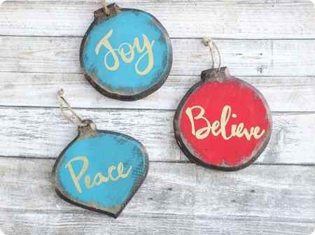 Set of three painted wooden ornaments with the words Joy, Believe, and Peace.