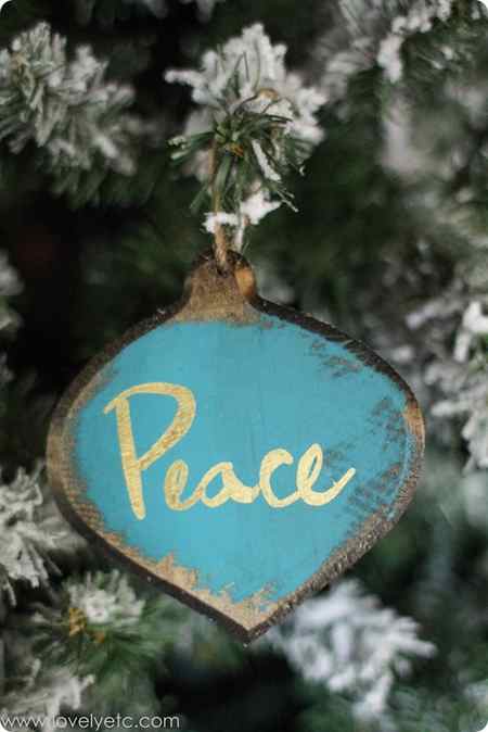 blue and gold rustic glam handmade peace ornament hanging on Christmas tree.