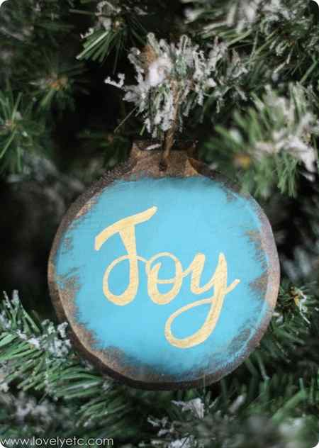 blue and gold joy diy ornament hanging on Christmas tree.
