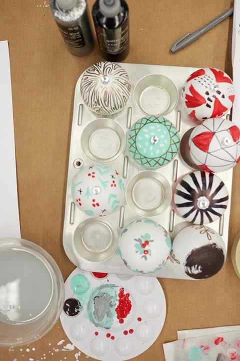 DIY ornament ideas: Hand-painted Christmas ornaments drying in a muffin tin