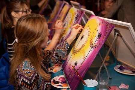 Group of women painting dandelions at Paint Nite