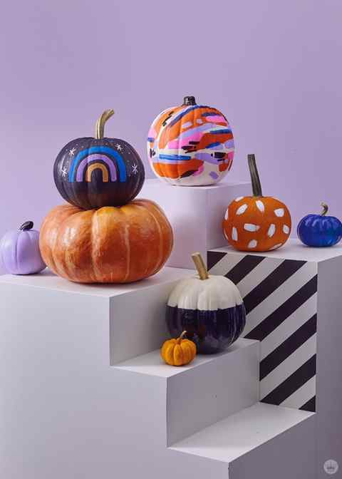 Pumpkins decorated with painted patterns, rainbows, and color blocks
