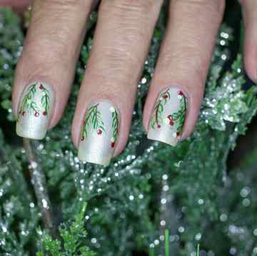 holiday inspired nail art with silver polish and mistletoe and berries painted on top