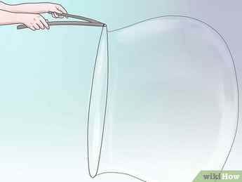 Step 2 Dip your giant bubble wand in a shallow container for huge bubbles.