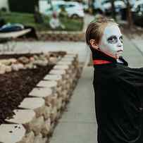 School Aged Boy Dressed As Dracula Trick-or-treating During Halloween by Cavan Images